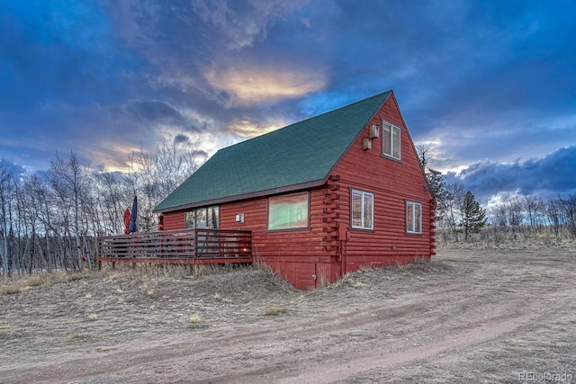 view of side of property featuring log siding and roof with shingles