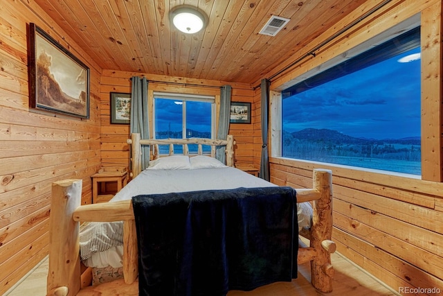 bedroom with visible vents, wood walls, and wood ceiling