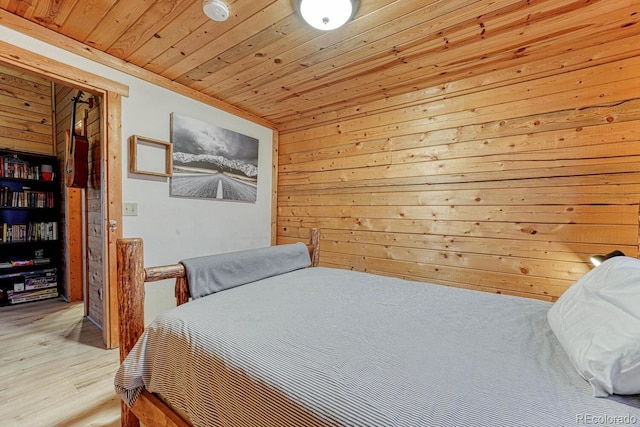 bedroom featuring wooden ceiling, light wood-style floors, and wood walls