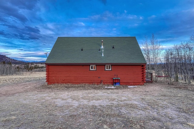 view of property exterior featuring a barn and log siding