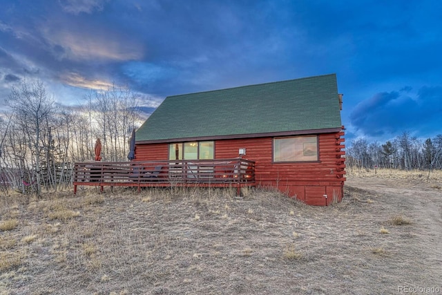 view of side of property featuring roof with shingles and log exterior