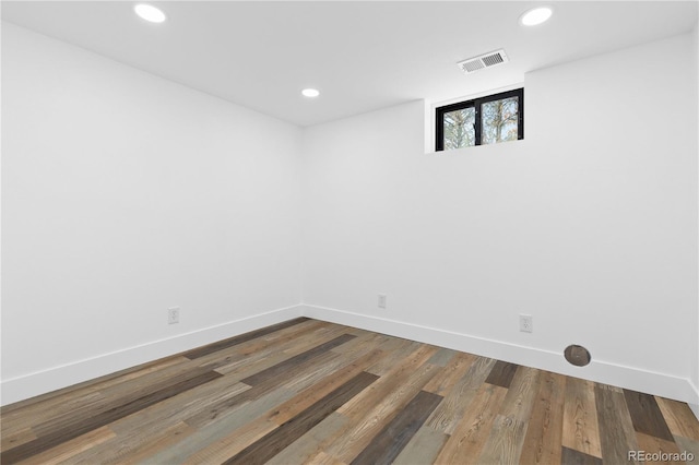 empty room with baseboards, recessed lighting, and wood finished floors
