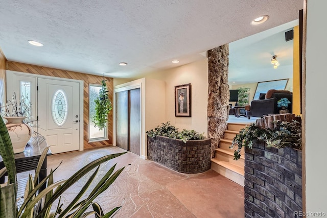 6227 Colorow Dr, Morrison, CO 80465 - foyer with stone finish floor, wooden walls, recessed lighting, and a textured ceiling