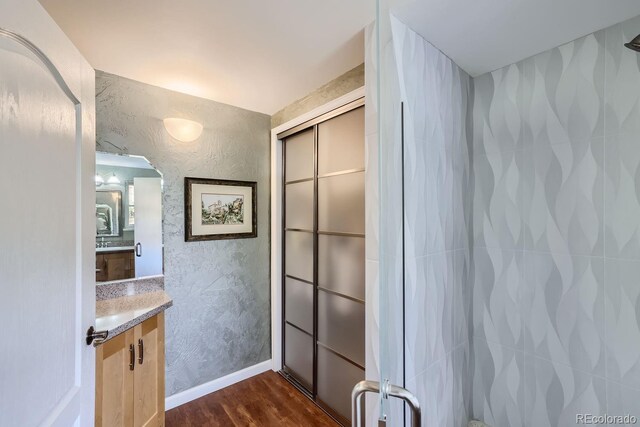 6227 Colorow Dr, Morrison, CO 80465 - full bath featuring vanity, a textured wall, baseboards, and wood finished floors