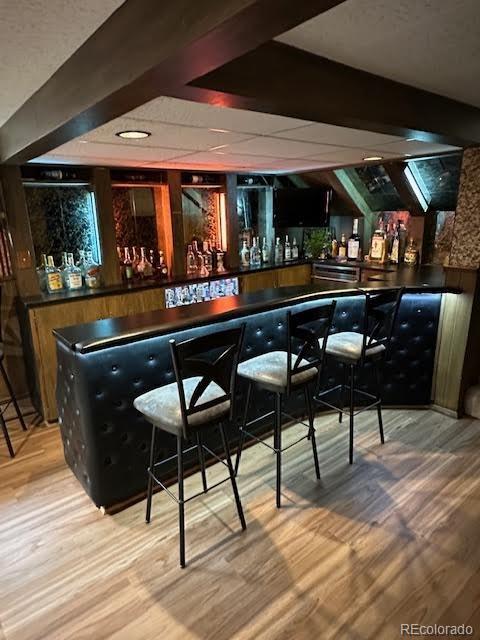 6227 Colorow Dr, Morrison, CO 80465 - bar with a dry bar, wood finished floors, and beam ceiling