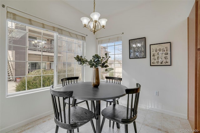 dining area with a chandelier, baseboards, and light tile patterned floors