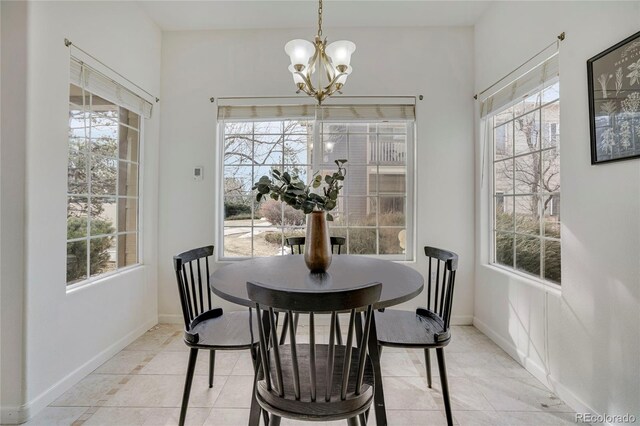 dining area with a chandelier, baseboards, and light tile patterned floors