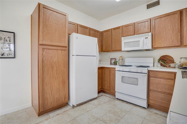 kitchen featuring white appliances, visible vents, and light countertops