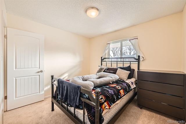 bedroom featuring light carpet and a textured ceiling