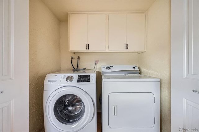 laundry area featuring cabinets and washing machine and dryer