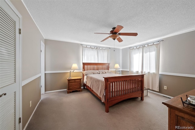 bedroom with crown molding, light carpet, and a textured ceiling