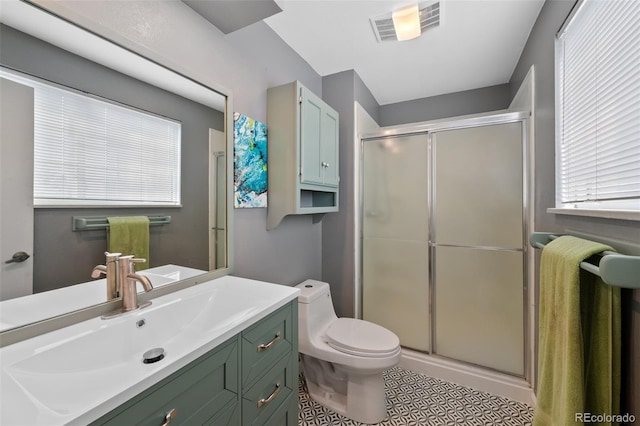 bathroom featuring vanity, toilet, and a shower with door