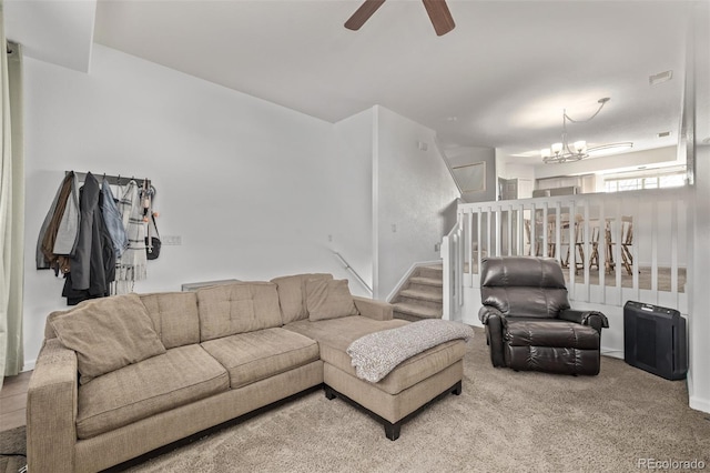 living area featuring stairs, carpet, ceiling fan with notable chandelier, and visible vents