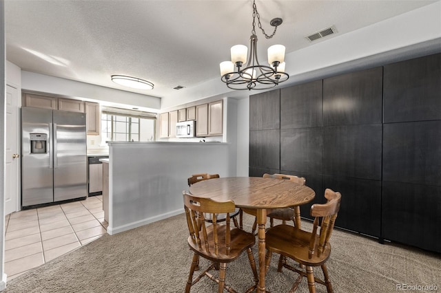 dining room featuring light tile patterned floors, visible vents, an inviting chandelier, a textured ceiling, and light colored carpet