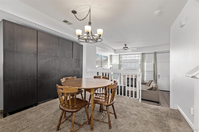 carpeted dining room with visible vents, baseboards, and ceiling fan with notable chandelier