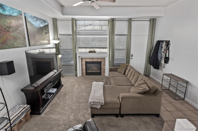 living area with tile patterned floors, a fireplace, baseboards, and ceiling fan