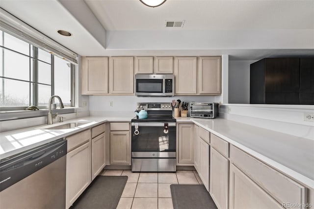 kitchen with visible vents, light countertops, light tile patterned floors, appliances with stainless steel finishes, and a sink