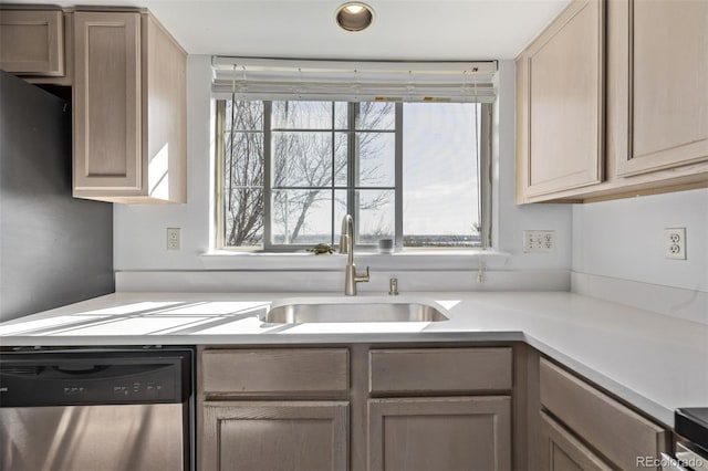 kitchen featuring dishwasher, light countertops, and a sink