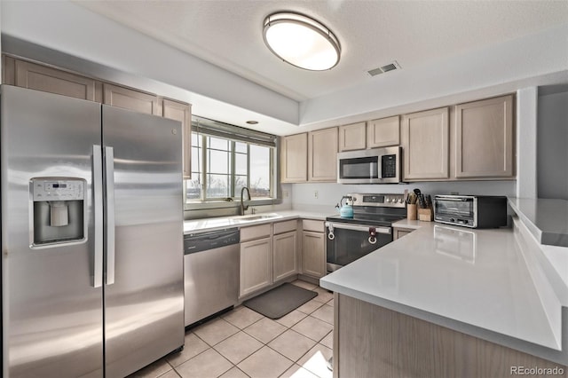 kitchen featuring visible vents, a toaster, light tile patterned floors, stainless steel appliances, and a sink