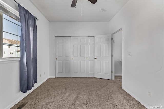 unfurnished bedroom featuring visible vents, a ceiling fan, a closet, carpet floors, and baseboards