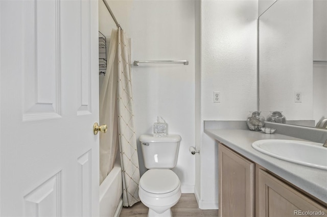 bathroom featuring vanity, shower / bath combination with curtain, toilet, and wood finished floors