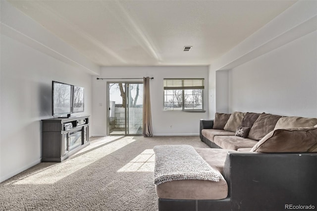 living room featuring visible vents, baseboards, and carpet floors