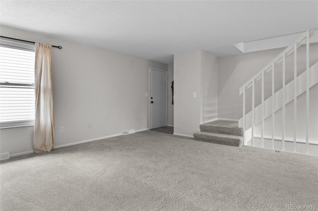 4262 E Maplewood Way, Centennial, CO 80121 - unfurnished living room with stairway, carpet, baseboards, and a textured ceiling