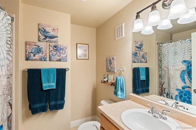 bathroom featuring vanity, toilet, and curtained shower