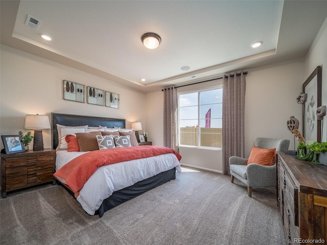 carpeted bedroom with a tray ceiling