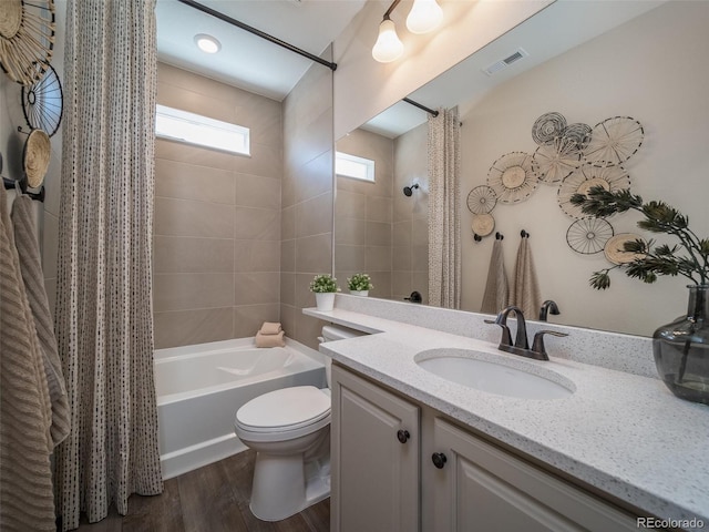 full bathroom featuring wood-type flooring, toilet, shower / tub combo, and vanity