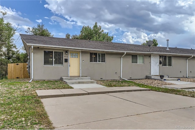 single story home featuring stucco siding, roof with shingles, and fence