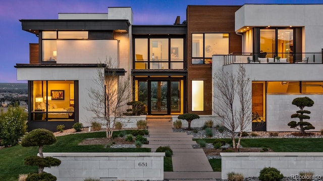 back of property featuring french doors and a balcony