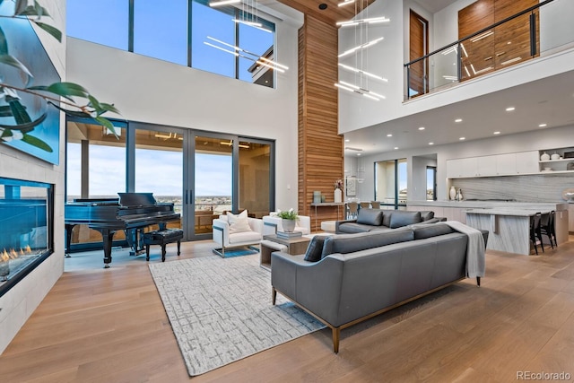 living area with light wood-type flooring and a high ceiling