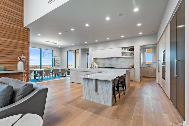 kitchen with open shelves, a large island, modern cabinets, recessed lighting, and white cabinets