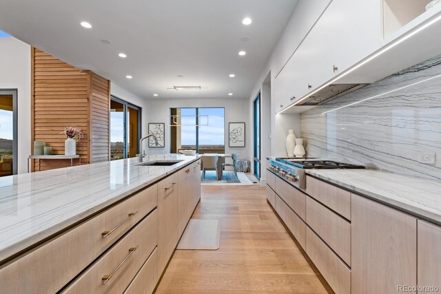 kitchen featuring recessed lighting, a sink, and light brown cabinets