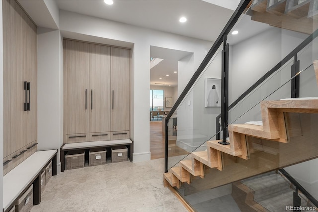 staircase with recessed lighting, a barn door, and marble finish floor