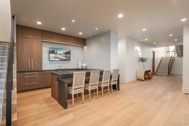 bar with stairway, baseboards, light wood-style floors, and recessed lighting