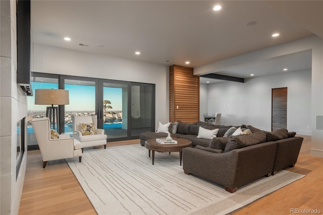 living room with recessed lighting, visible vents, light wood-style flooring, and a fireplace