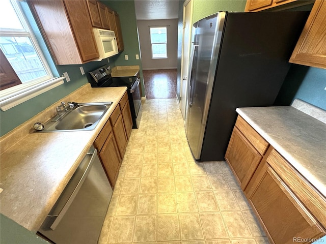 55619 E 31st Ave, Strasburg, CO 80136 - kitchen with appliances with stainless steel finishes, brown cabinetry, and light countertops