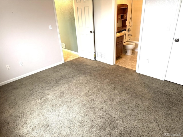 55619 E 31st Ave, Strasburg, CO 80136 - unfurnished bedroom featuring light colored carpet and connected bathroom