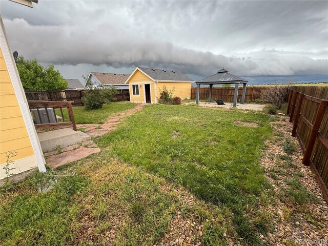 55619 E 31st Ave, Strasburg, CO 80136 - fenced backyard featuring a gazebo, a patio area, and an outdoor structure