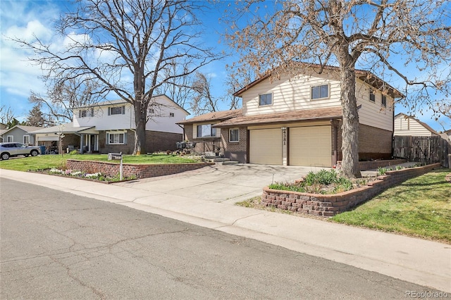 traditional-style house featuring a front yard, brick siding, driveway, and an attached garage