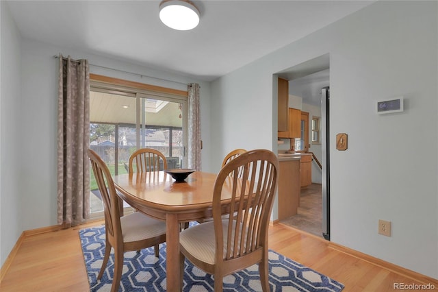 dining room featuring light wood-style floors and baseboards
