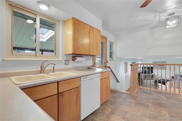kitchen featuring ceiling fan, stone finish flooring, dishwasher, light countertops, and a sink