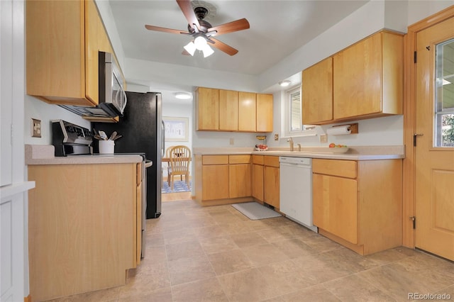 kitchen featuring stainless steel microwave, light countertops, ceiling fan, white dishwasher, and light brown cabinetry