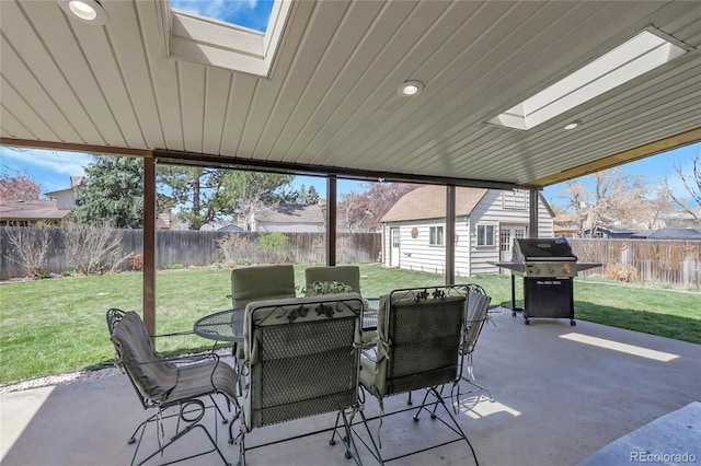 view of patio / terrace featuring area for grilling, a fenced backyard, outdoor dining area, and an outdoor structure