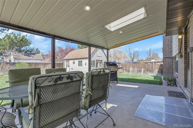view of patio with a fenced backyard, an outdoor structure, and grilling area