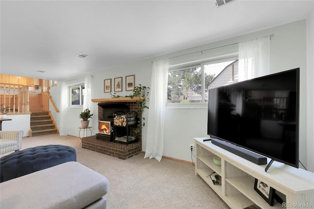 living room featuring a wealth of natural light, stairs, a fireplace, and carpet floors