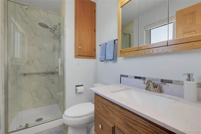 full bath featuring toilet, vanity, and a marble finish shower