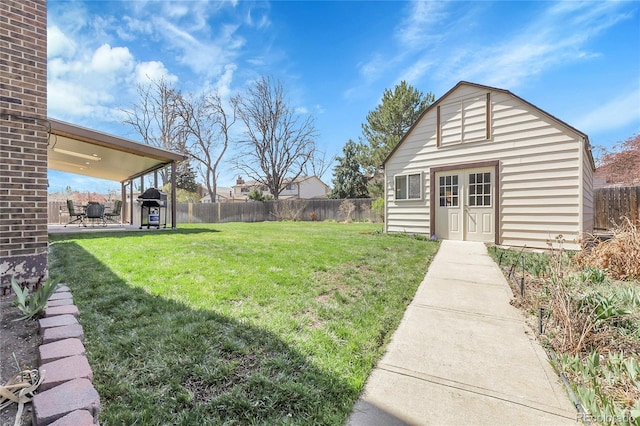 view of yard with a fenced backyard, an outdoor structure, and a patio